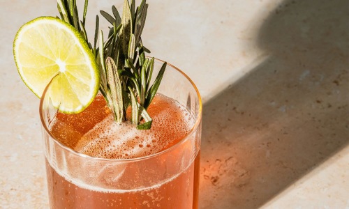a glass with a drink and a lemon on top