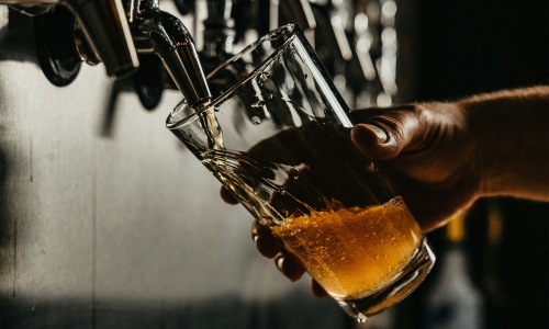 someone pouring a glass of beer